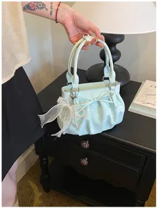 Detailed view of the stylish ruched polka dot handbag, soft leather cloud shoulder bag design.