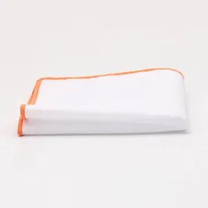 Close-up detail view of white men pocket square with orange trim, elegant suit accessory.
