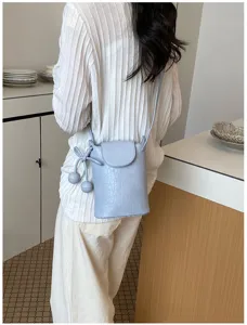 Kleine Leder Umhängetasche in Hellblau, schickes Eimer-Design mit süßen Kugeln für Damen.