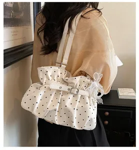 Detail shot of the white polka dot pleated shoulder bag, showcasing stylish ruffles and bow.