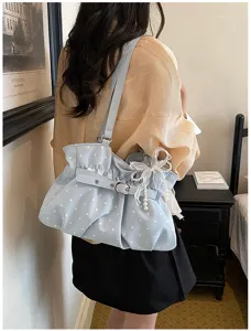 Chic light blue polka dot ruffled shoulder bag detail showing bow and pearl charm decoration.