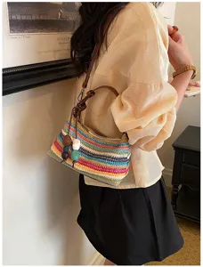 Primo piano della borsa a tracolla in paglia intrecciata colorata con nappe di perline.