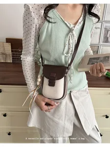 Chic vintage canvas and leather crossbody phone bag detail view with cute flower charm.