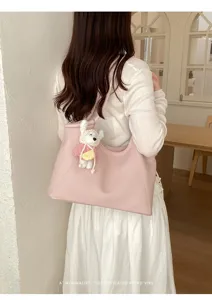 Detail view of the pink minimalist shoulder tote bag featuring a cute plush pendant.