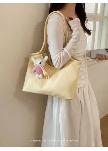 Fashionable large capacity shoulder tote bag in soft yellow with cute knit bear charm.