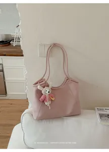 Pink leather tote bag with cute knit rabbit pendant, stylish casual shoulder bag for women.