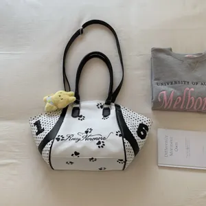 Elegante bolso de hombro a lunares blancos y negros con huellas y peluche colgante.