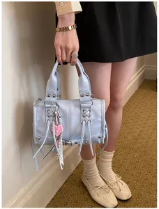 Light blue leather boston handbag detail, stylish studded bag with chic heart charm.