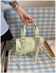 Light green patent leather Boston handbag with studs, tassels and chic commuter daily style.