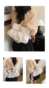 Detail view of the stylish white polka dot gathered shoulder bag with delicate pearl decor.