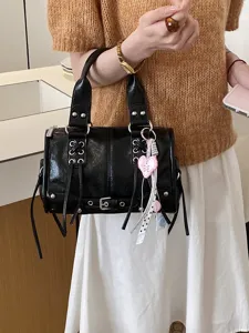 Black patent leather boston shoulder bag with metal grommets and heart charm for women.