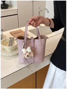 Stilvolle hellviolette Leder-Eimertasche mit einem süßen Hundeanhänger für Damen
