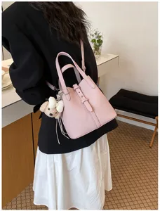 Detailaufnahme einer eleganten rosa Leder-Eimer-Tasche mit tollem Anhänger und Griff.