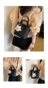 Klassische schwarze Leder-Eimer Tasche mit Henkel und niedlichem Plüsch-Anhänger.