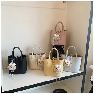 Detailansicht stilvoller Eimerentaschen in vielen Farben mit niedlichem Welpen-Anhänger.
