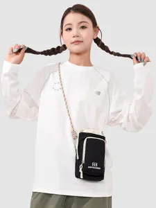 Kids crossbody phone bag and casual long sleeve top main product view worn by model.