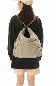 Vista trasera detallada que muestra la mochila de lona con múltiples bolsillos y correas.