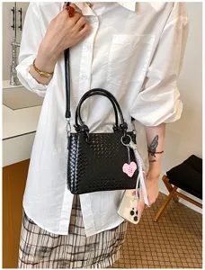 Black woven bucket bag for women, stylish top handle shoulder crossbody bag with charm.