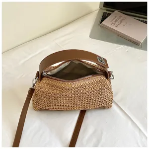 Bolso cruzado de paja tejido vista de detalle, asa de piel marrón, bolso estilo cojín elegante.