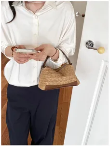Detalle del elegante bolso de paja tejido con ribete de cuero marron y cremallera practica.