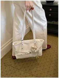 Vue détaillée du sac cabas souple minimaliste avec bandoulière élégante et charm peluche.