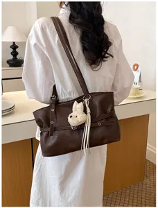 Élégant sac cabas bandoulière en cuir souple marron foncé avec charm pour femmes chic.