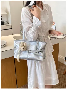 Détail de sac cabas souple en cuir argenté, grand sac d'épaule élégant pour le travail.