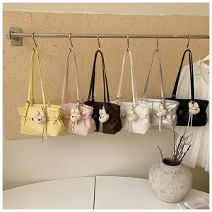 Détail de sac cabas en cuir souple, sac porté épaule minimaliste avec adorable breloque en peluche.