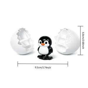 Juguete de pinguino de cuerda saliendo de huevo de plastico divertido 6.8x9.5cm