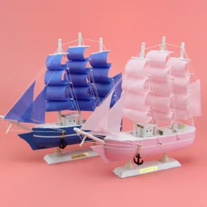 Detailaufnahme eines hölzernen Segelschiffsmodells mit blauen und rosafarbenen Ornamenten.