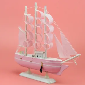 Rosa hoelzernes Segelboot Modell Ornament, feine Stoffsegel und mini Ankeranhaenger Detail.