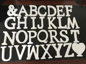 White wooden letter ornaments detail shot, showing alphabet set arranged nicely for decor.