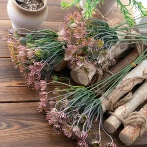 Vista detallada de ramos de flores rosas artificiales en madera rústica para decoración.