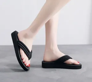 Vue détaillée des tongs compensées noires pour femmes, bride en tissu semelle épaisse.