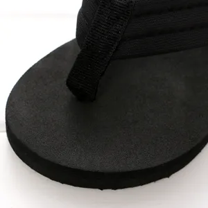 Nahaufnahme der schwarzen Zehentrenner Riemen und dicken Sohlenstruktur für den Strand.