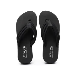Sandales tongs compensées noires pour femmes avec lanière en tissu, idéales pour la plage d'été.