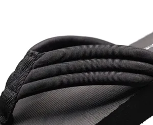 Détail de sandale tong noire pour femme, tenue de plage décontractée avec lanière texturée.