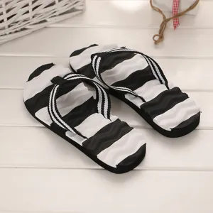 Detailansicht der stylischen schwarz-weißen Zehentrenner für sommerliche Strandspaziergänge.