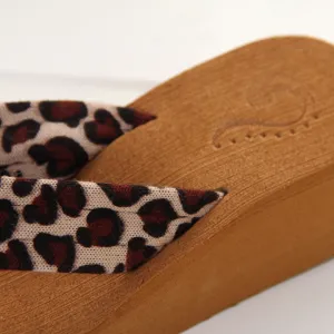 Detailansicht von Damen Keilabsatz Zehentrenner mit Leopardenmuster Riemen und Holzsohle.