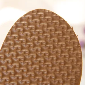 Nahaufnahme der strukturierten braunen Schuhsohle mit geometrischem Rautenmuster.