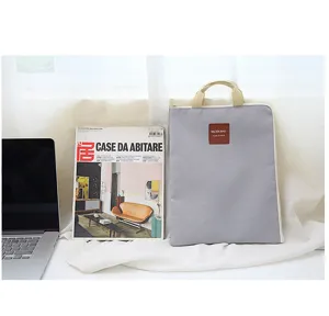 Graue Laptoptasche aus Segeltuch A4 Dokumententasche mit beigen Griffen und Reißverschluss.