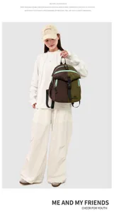 Detail shot of a trendy double-decker backpack in brown and green, shown worn by a model.