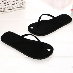 Schwarze minimalistische Flip-Flops Detailansicht auf weißem Hintergrund, bequeme Sommerschuhe.