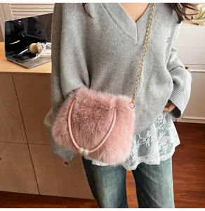 Chic pink faux fur crossbody bag with elegant pearl handle and gold chain strap for women.