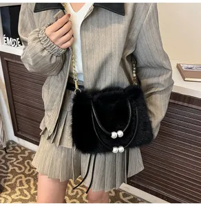 Detail shot of a black plush shoulder bag with pearl handle and chain strap for stylish outfit.