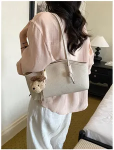 Elegante Damen Umhängetasche Detail, schicke Baguette Tasche mit süßem Bärenanhänger für Alltag.