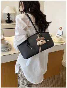 Detailansicht der schwarzen Schultertasche mit niedlichem Bärenanhänger für Damen Pendler