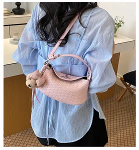Pink woven shoulder bag detail, stylish dumpling purse with cute bow bear charm and metal lock.
