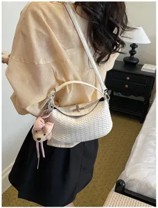 White woven shoulder bag detail, stylish dumpling crossbody bag with cute bear charm for women.