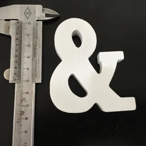 White wooden ampersand symbol display piece detail shot with caliper measurement tool.